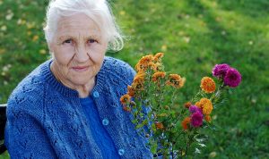Senior Lady with flowers green bkgnd V2